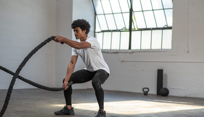man exercising with two ropes
