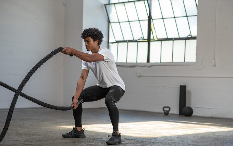 man exercising with two ropes